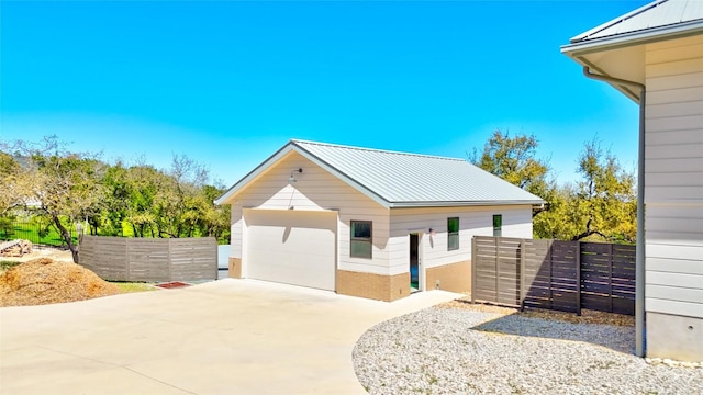 view of front of home featuring a garage, fence, and an outdoor structure
