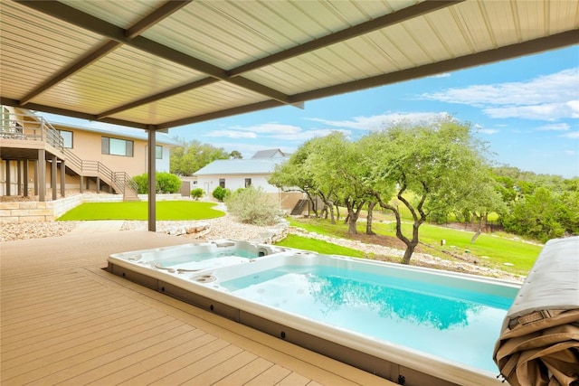 view of pool featuring a yard, a deck, and stairway