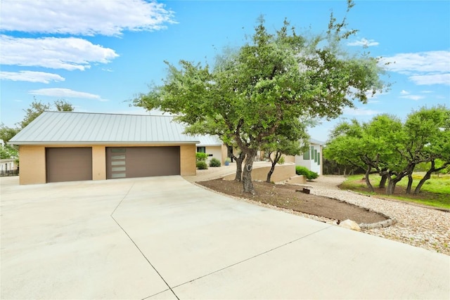 view of front of home with metal roof and concrete driveway