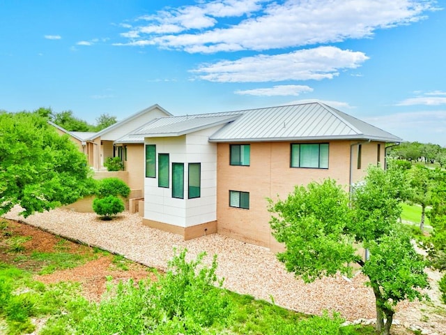 rear view of house featuring metal roof and a standing seam roof
