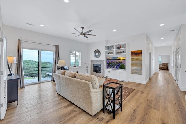 living area featuring a fireplace, light wood finished floors, ceiling fan, recessed lighting, and baseboards