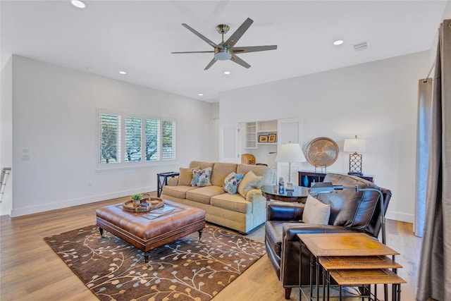 living room featuring a ceiling fan, light wood-style floors, recessed lighting, and baseboards