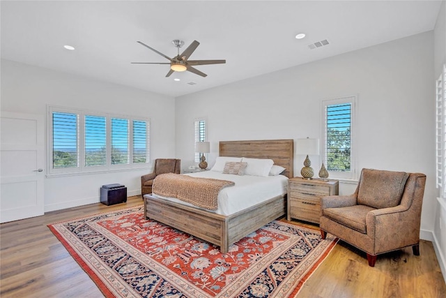 bedroom featuring wood finished floors, a ceiling fan, recessed lighting, and baseboards