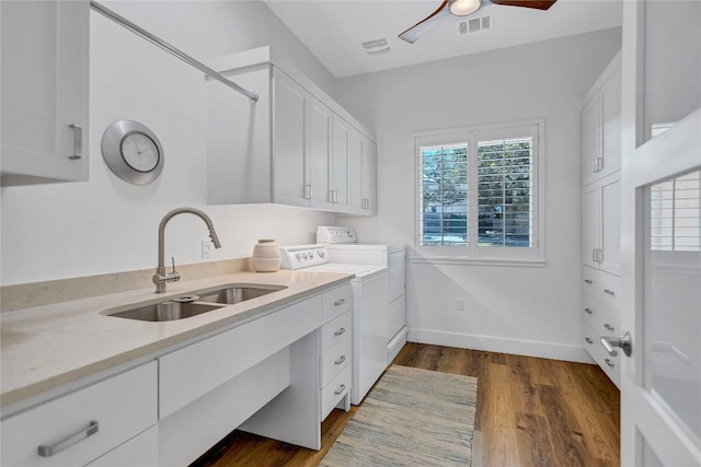 laundry room with washer and clothes dryer, cabinet space, dark wood-type flooring, a ceiling fan, and baseboards