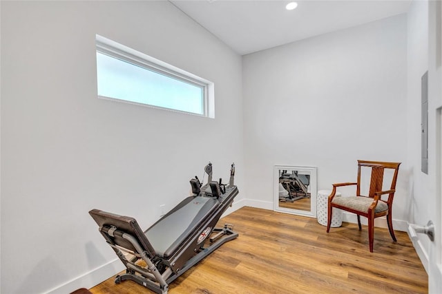 workout area featuring light wood-style flooring, baseboards, and recessed lighting