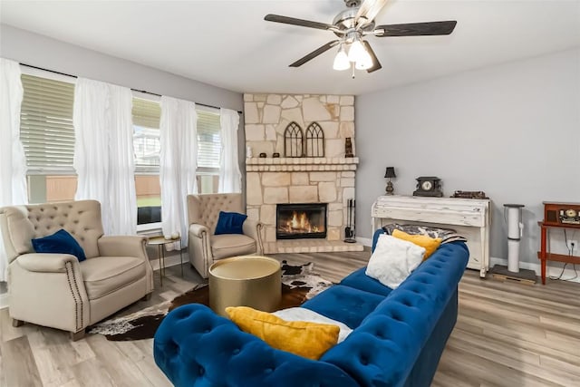 2017 Prickly Pear Dr, Bastrop, TX 78602 - living area featuring ceiling fan, wood finished floors, a stone fireplace, and baseboards