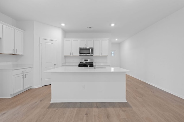 2416 Cattle Baron Trl, Leander, TX 78641 - kitchen featuring stainless steel appliances, a sink, light wood finished floors, light countertops, and white cabinetry