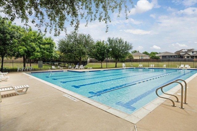 community pool featuring fence and a patio