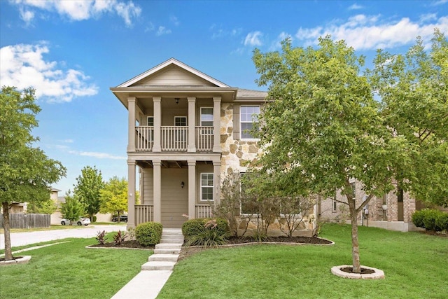 view of front facade featuring a porch, a balcony, and a front lawn