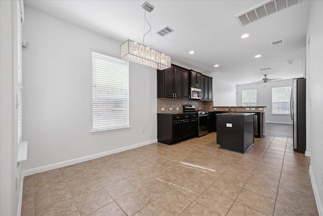 2500 Mcdonald Way, Austin, TX 78754 - kitchen featuring appliances with stainless steel finishes, tasteful backsplash, a ceiling fan, a center island, and recessed lighting