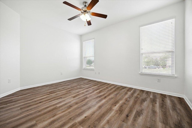 empty room with ceiling fan, dark wood-style flooring, and baseboards