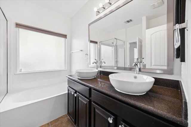 bathroom featuring double vanity, a garden tub, and tile patterned flooring