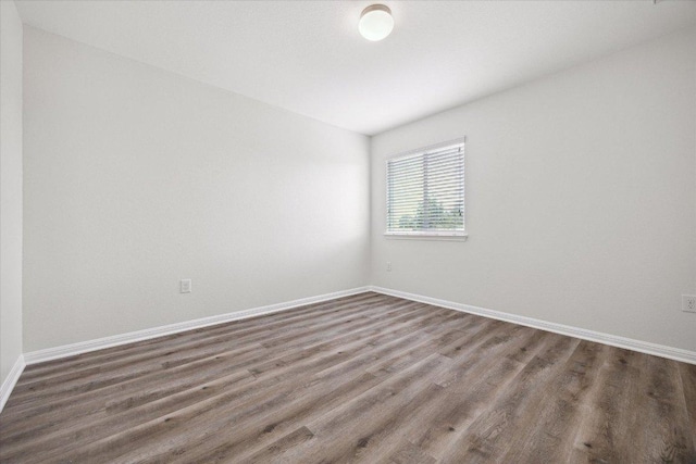 unfurnished room with wood finished floors and baseboards