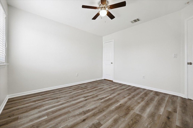 empty room featuring wood finished floors, ceiling fan, and baseboards