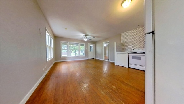 unfurnished living room featuring baseboards, wood-type flooring, and a ceiling fan