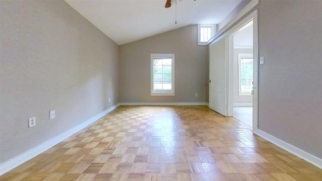 empty room featuring lofted ceiling, ceiling fan, and baseboards