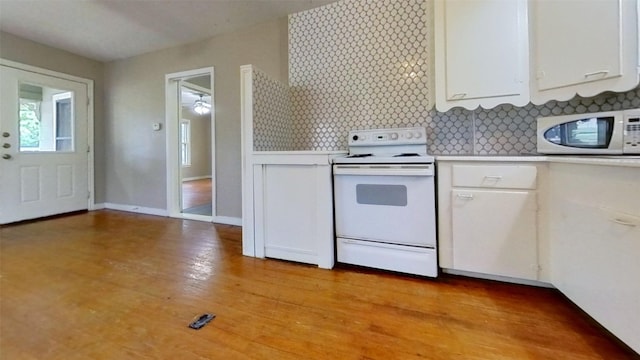 kitchen with white appliances, white cabinets, light countertops, and light wood-type flooring