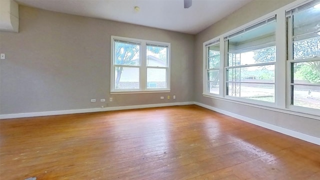 spare room featuring hardwood / wood-style floors, baseboards, and ceiling fan
