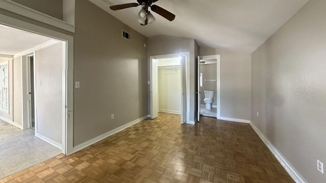 unfurnished bedroom with vaulted ceiling, baseboards, ensuite bath, a ceiling fan, and a closet