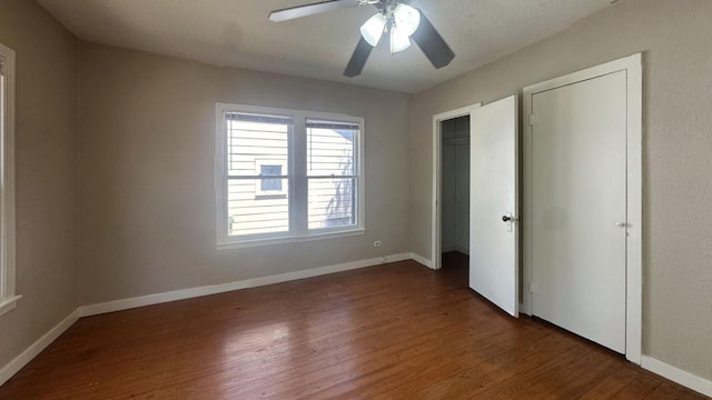 unfurnished bedroom featuring wood finished floors, baseboards, and a ceiling fan