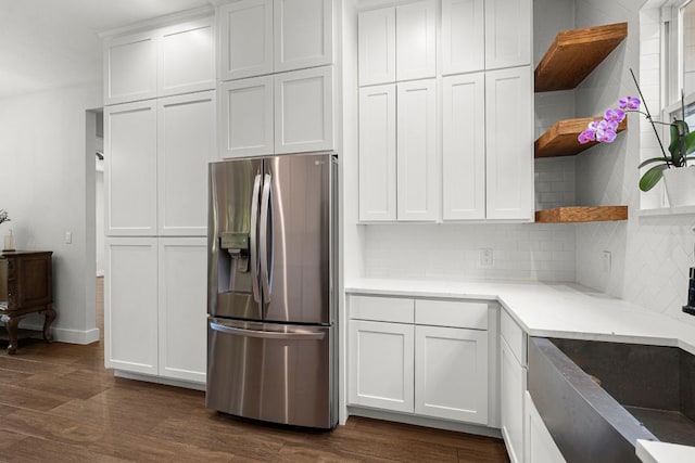kitchen with stainless steel refrigerator with ice dispenser, open shelves, backsplash, dark wood-type flooring, and white cabinetry