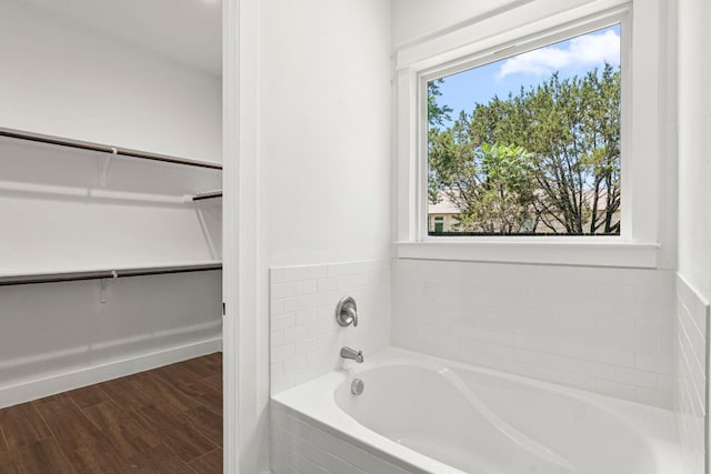 4 La Toya Trl, Wimberley, TX 78676 - full bathroom featuring a garden tub, a spacious closet, and wood finished floors