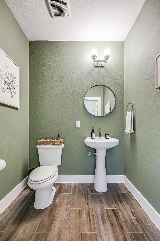 4609 Unity Cir, Austin, TX 78731 - bathroom with wood finished floors, toilet, and baseboards
