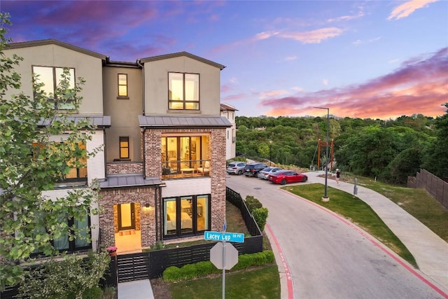 4609 Unity Cir, Austin, TX 78731 - view of front facade with a standing seam roof, brick siding, stucco siding, a balcony, and metal roof