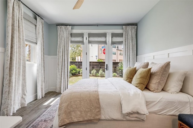 4609 Unity Cir, Austin, TX 78731 - bedroom with access to outside, multiple windows, a wainscoted wall, wood finished floors, and ceiling fan
