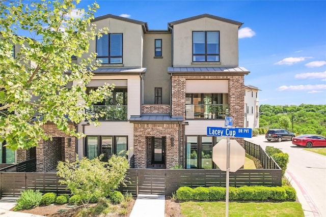 4609 Unity Cir, Austin, TX 78731 - contemporary house featuring a standing seam roof, brick siding, and metal roof
