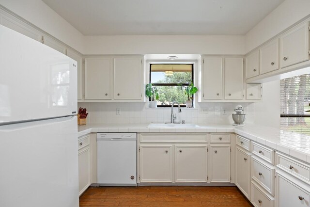 315 Juniper Dr, Mountain City, TX 78610 - kitchen with white appliances, a sink, white cabinetry, decorative backsplash, and wood finished floors