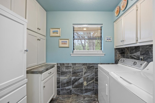 315 Juniper Dr, Mountain City, TX 78610 - laundry area featuring cabinet space, tile walls, washing machine and dryer, marble finish floors, and a textured ceiling