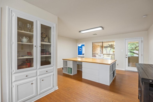 315 Juniper Dr, Mountain City, TX 78610 - kitchen with white cabinets, light wood-type flooring, an office area, and butcher block countertops