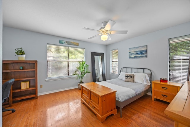 315 Juniper Dr, Mountain City, TX 78610 - bedroom with multiple windows, baseboards, wood finished floors, and a ceiling fan
