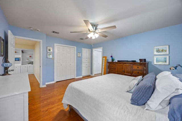 315 Juniper Dr, Mountain City, TX 78610 - bedroom featuring multiple closets, wood finished floors, baseboards, and ceiling fan