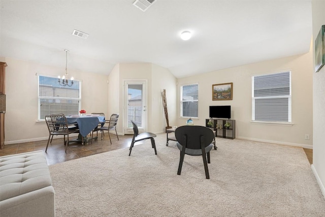 carpeted living room with a chandelier, vaulted ceiling, baseboards, and healthy amount of natural light