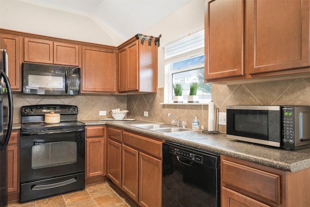 kitchen featuring black appliances, a sink, lofted ceiling, decorative backsplash, and brown cabinets