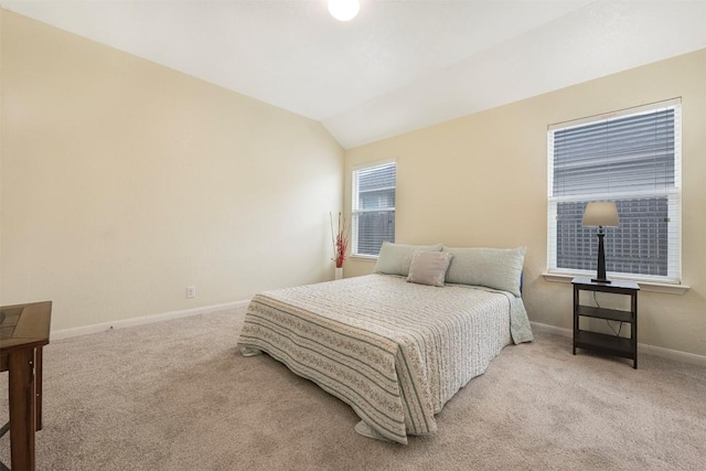 carpeted bedroom with vaulted ceiling and baseboards