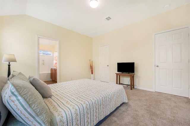 bedroom with light carpet, baseboards, and ensuite bath