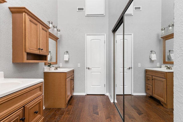 7122 Wood Hollow Dr Unit 13, Austin, TX 78731 - full bath with two vanities, wood finished floors, a towering ceiling, and a textured wall