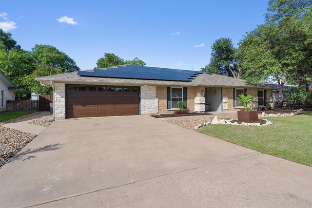 531 Dennis Dr, Round Rock, TX 78664 - ranch-style house featuring driveway, a garage, and roof mounted solar panels