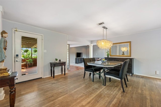 5900 Nasco Dr, Austin, TX 78757 - dining room featuring wood finished floors, a chandelier, crown molding, and baseboards