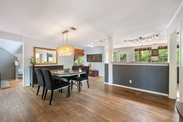 5900 Nasco Dr, Austin, TX 78757 - dining space featuring hardwood / wood-style floors, healthy amount of natural light, ornate columns, and a chandelier