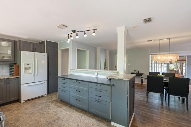 5900 Nasco Dr, Austin, TX 78757 - kitchen with white fridge with ice dispenser, gray cabinetry, a chandelier, light stone counters, and glass insert cabinets