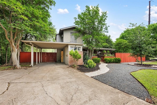 5900 Nasco Dr, Austin, TX 78757 - view of front facade with fence, a carport, concrete driveway, and brick siding