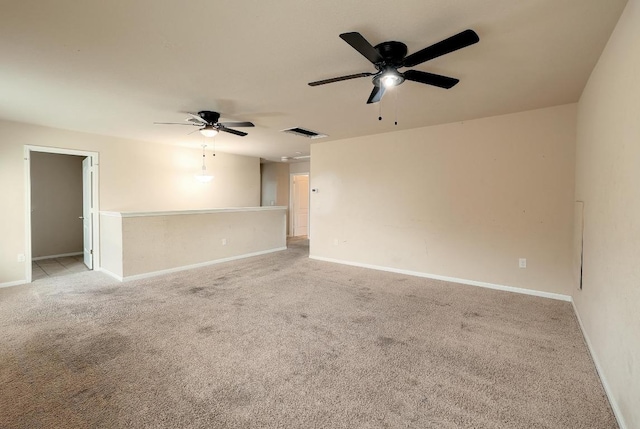 empty room with ceiling fan, light carpet, and baseboards