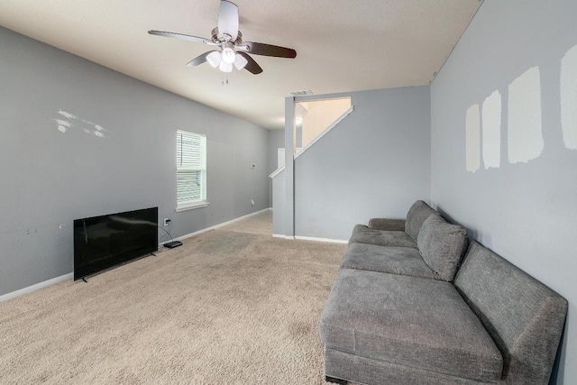 carpeted living room with a ceiling fan and baseboards