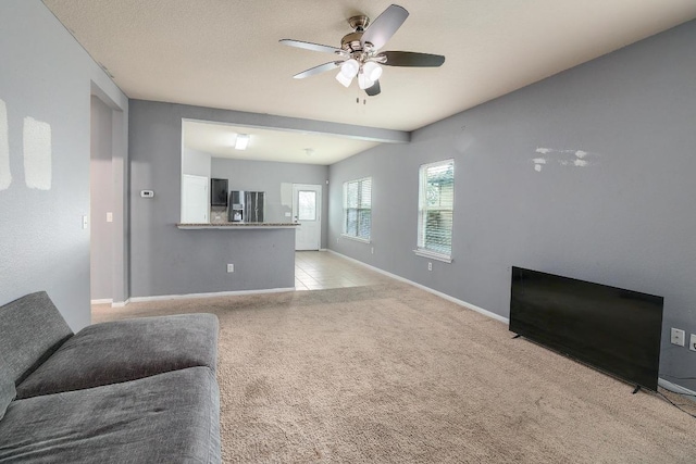 living area with a ceiling fan, baseboards, and light carpet