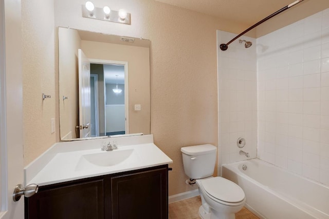 full bathroom featuring a textured wall, toilet, vanity, and bathing tub / shower combination