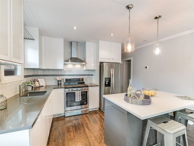 701 Bouldin Ave, Austin, TX 78704 - kitchen featuring appliances with stainless steel finishes, wall chimney range hood, white cabinetry, crown molding, and decorative backsplash